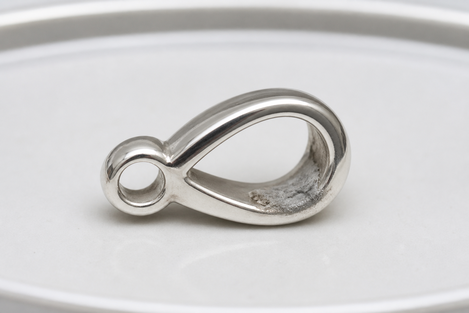 Pale polishing-compound residue remaining in a metal component before coating.