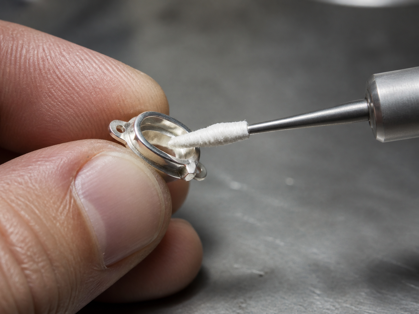 A tapered small spindle with a hand-made cotton wrap positioned at a confined metal edge.